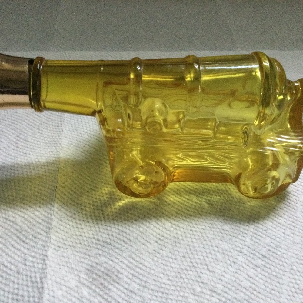 Glass bottle empty yellow amber cannon shape AVON?